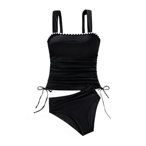 Detailansicht des schwarzen Bikinis mit weißer Zackenlitze und strukturierter Falten