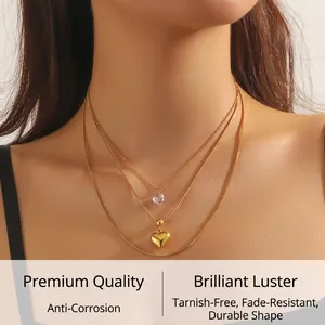 Detailed view of layered gold snakeskin chain necklace featuring heart-shaped pendants