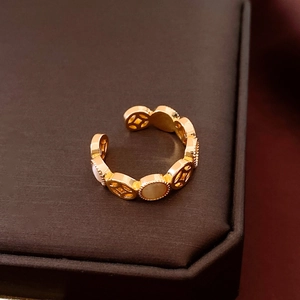 Detail of adjustable gold ring with hollowed coin pattern and white shell inlay