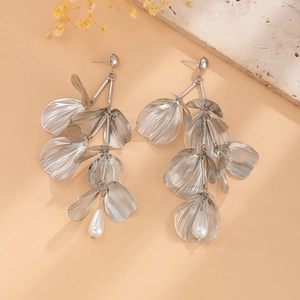 Macro shot of silver layered ginkgo leaf earrings with white teardrop pearls