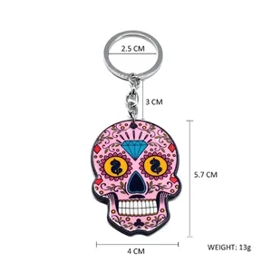 Pink sugar skull keychain with dollar sign eyes and diamond detail on a white background