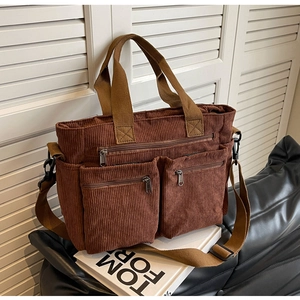 Brown corduroy tote bag detail showing multiple zipper pockets and canvas straps
