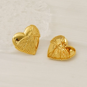 Detailed view of gold heart earrings with silk-like textured finish and pin back closure