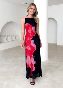 Détail d'une robe longue noire ajustée avec imprimé floral rouge et fines bretelles