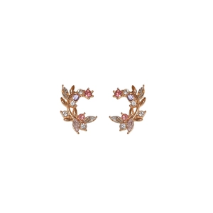 Vintage gold crescent earrings with leaf motifs and colorful crystals on white background