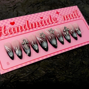 Faux ongles faits main dégradé rose et noir avec lignes argentées et breloques de croix