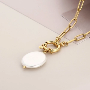 Golden paperclip chain necklace featuring a large baroque white pearl pendant and toggle clasp