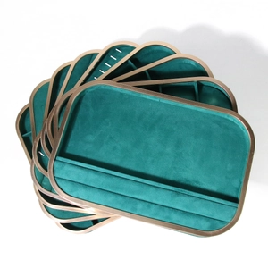 Golden aluminum jewelry trays with emerald microfiber lining stacked in a fan layout