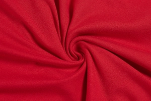 Detailed macro view of the premium red knitted fabric texture with elegant soft draping