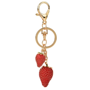 Golden keychain with red enamel strawberry pendants and green leaves on white background