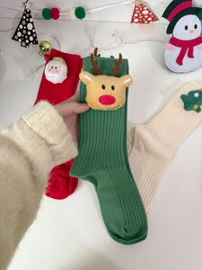 Detail of cotton Christmas socks with 3D Santa, reindeer, and tree plush decorations