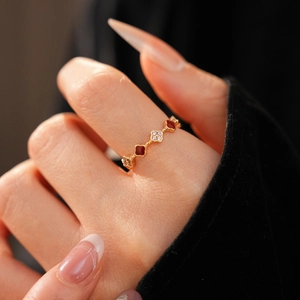 Close-up of 18k gold-plated ring with red enamel and white zircon clover patterns