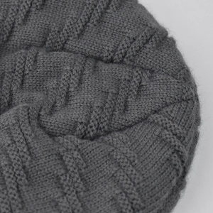 Detailed close-up of grey chunky knit wool texture with elegant cable stitching patterns