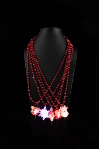 Dettaglio della collana a perle rosse multistrato con ciondoli natalizi luminosi