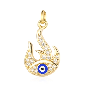Detailed close-up of a gold flame-shaped pendant with a blue evil eye and sparkling zircons