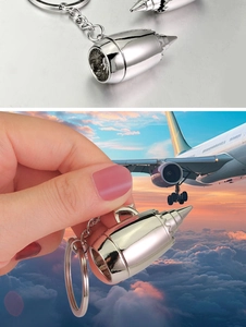 Macro shot of a polished silver aircraft engine turbine keychain with detailed metal blades