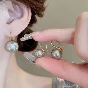 Elegant 18K gold grey pearl hook earrings for women featuring polished metallic luster
