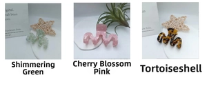Close-up of acetic acid hair claws in blue, pink and tortoiseshell with wave-tooth design