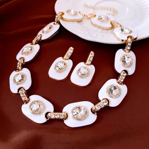 Parure de bijoux vintage dorée avec émail blanc et cristaux scintillants