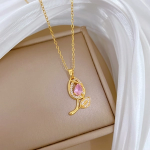 Macro shot of pink tulip pendant necklace with pavé crystals on a silk backdrop
