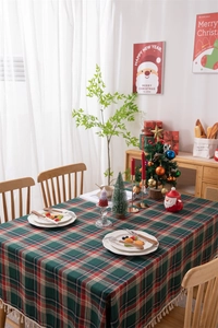 Macro shot showing red and green plaid patterns with elegant decorative tassels on Christmas cloth