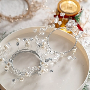 Handmade pearl and crystal wreath ornaments with silver wire on elegant holiday tray