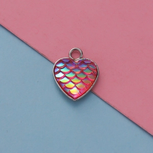 Dettaglio del ciondolo a cuore con scaglie di sirena in sfumature rosa e dorato