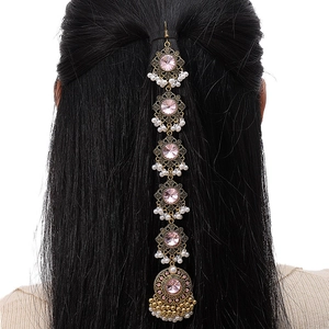Detail of ethnic gold Maang Tikka with pink crystals and pearls on dark hair