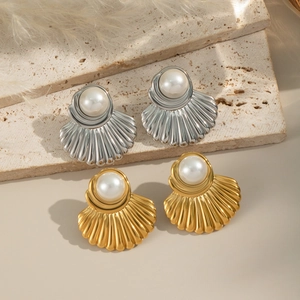 Dettaglio di orecchini vintage a forma di conchiglia in oro e argento con perle