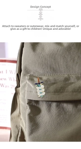 Detail of a sword enamel pin with Fighting Invisible Battles inscription on a green bag