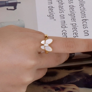Golden butterfly ring with white shell wings worn by a model in an elegant lifestyle setting