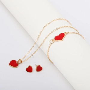 Golden jewelry set featuring red heart pendants on minimalist necklace, bracelet and earrings