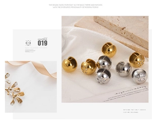 Detail of hollow round ball earrings in gold and silver with heart-shaped diamond accents