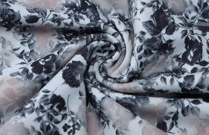 Detailed macro view of soft textile fabric with black and white floral prints on grey