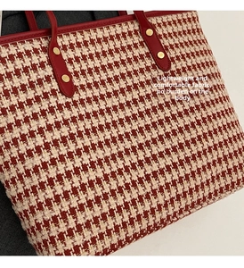 Close-up of red and white houndstooth fabric texture with leather strap and gold rivets