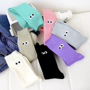 Detail of colorful ribbed cotton socks with cartoon eye embroidery in seven vibrant shades