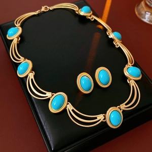 Detailed macro view of vintage turquoise jewelry set on a black textured leather display tray