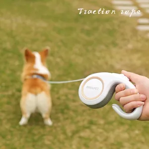 Retractable dog leash with 5m rope and ergonomic handle on a lush green grass background
