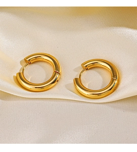 Macro shot of 18K gold plated stainless steel chunky hoop earrings on silk fabric
