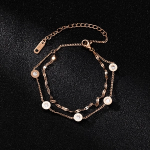 Detail of rose gold double-layer bracelet with Roman numeral rings and K18 engraving