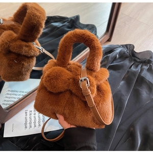 Close-up of fluffy brown plush bucket bag with cute ear details and leather strap