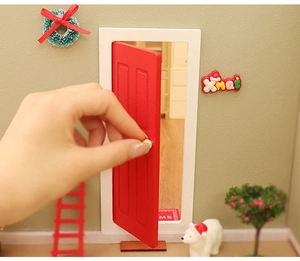 Hand opening miniature red Christmas dollhouse door with white frame and festive decor