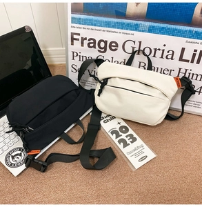 Close-up of minimalist black and beige crossbody bags with adjustable straps and plastic buckles