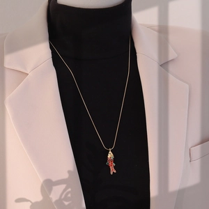 Détail d'un collier pendentif carpe koi 3D vintage en or sur un col roulé noir chic
