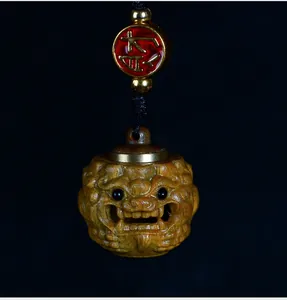 Detailed view of hand-carved sandalwood hollowed-out pendant with metal cap and lucky bead