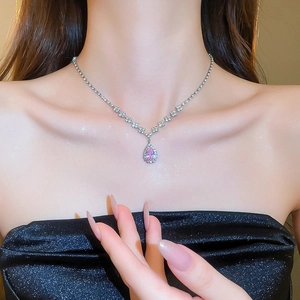 Close-up of pink teardrop crystal necklace with small diamonds on model neck