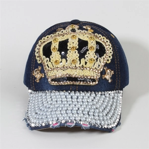 Detail of blue denim baseball cap with gold crown lace, pearls and skull charms