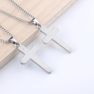 Détail de l'arrière de pendentifs en croix argentés montrant la finition en métal texturé