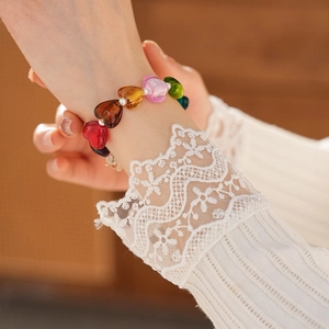 Close-up of heart-shaped colorful glass beads pearl bracelet on a model's wrist