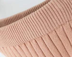 Detailed macro view of premium rib-knit texture and soft rosewood yarn stitching